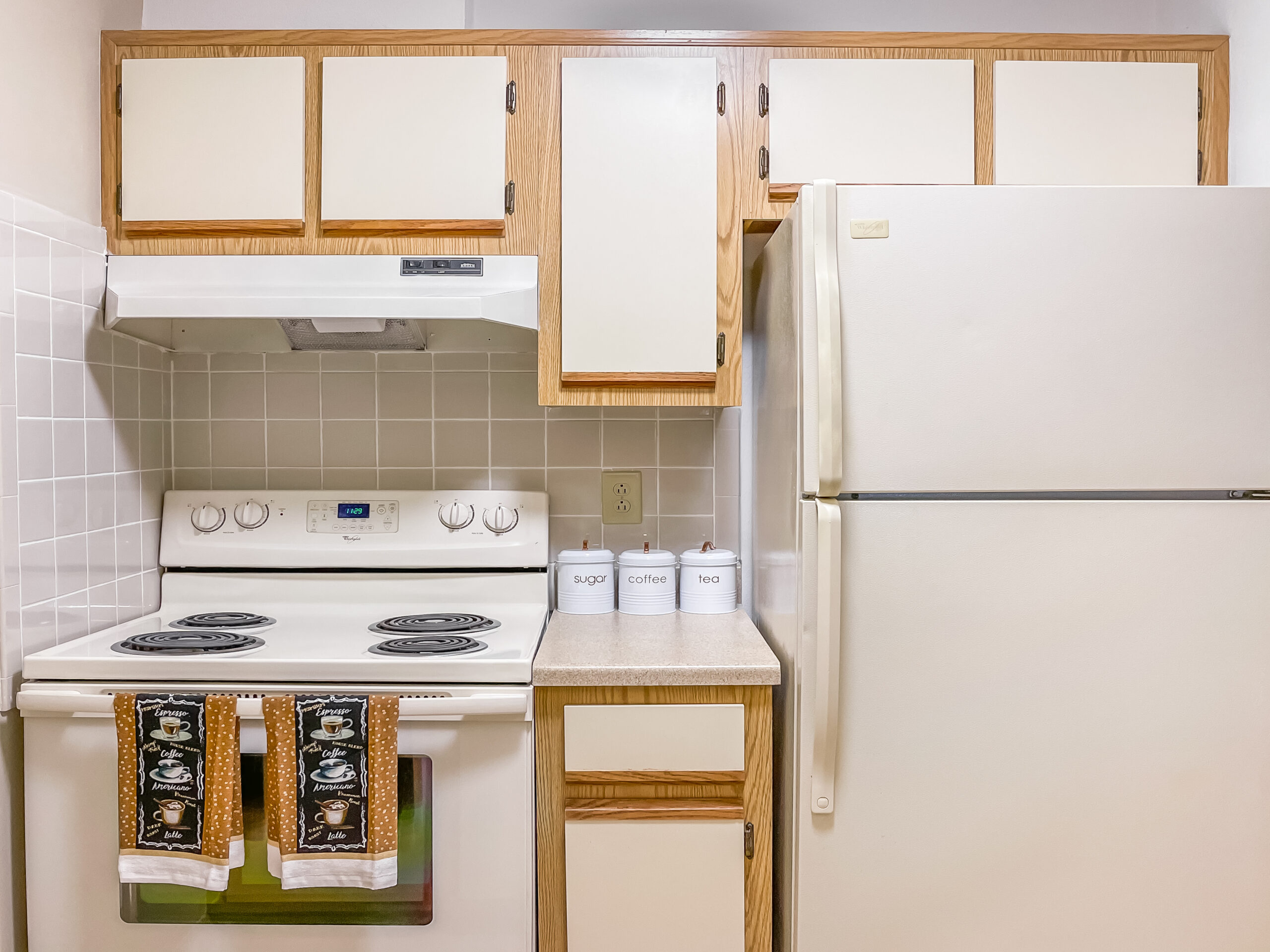 Kitchen Featuring Lower & Upper Cabinets With Fridge